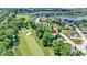Stunning aerial view of a home nestled on a golf course, surrounded by mature trees and a serene pond at 10585 Golden Bear Way, Noblesville, IN 46060
