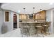 Beautifully crafted basement bar featuring stone accents, granite countertops, and seating for guests at 10585 Golden Bear Way, Noblesville, IN 46060