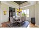 Elegant dining room with coffered ceilings, rustic table, and large windows overlooking the lush yard at 10585 Golden Bear Way, Noblesville, IN 46060