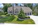 Beautiful home showcasing a three-car garage and lush green lawn with a stone-lined flower bed at 10585 Golden Bear Way, Noblesville, IN 46060