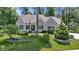 Charming stone home featuring manicured landscaping, a lush green lawn and mature trees at 10585 Golden Bear Way, Noblesville, IN 46060