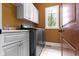 Practical laundry room featuring modern machines, cabinetry, counter space, and natural light at 10585 Golden Bear Way, Noblesville, IN 46060