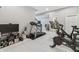 Well-equipped basement gym featuring Peloton bikes, treadmill, weights, and modern flooring at 10795 Creekbed Cir, Fishers, IN 46038
