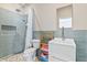 Bathroom featuring blue tile, a pebble floor shower, and wooden shelves for towels at 10795 Creekbed Cir, Fishers, IN 46038