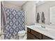 Cozy bathroom features a shower with patterned curtain, white vanity, and neutral wall paint at 10795 Creekbed Cir, Fishers, IN 46038