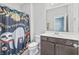 Well-lit bathroom featuring a modern vanity, toilet, and a shower with decorative curtain at 10795 Creekbed Cir, Fishers, IN 46038