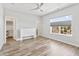 Bright bedroom with hardwood floors, ceiling fan, large window with blinds, and walk-in closet at 10795 Creekbed Cir, Fishers, IN 46038