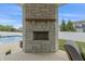 Stone fireplace with outdoor furniture on a covered patio, near backyard and pool at 10795 Creekbed Cir, Fishers, IN 46038