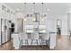 Bright kitchen with large island, stainless appliances, modern pendant lights, and breakfast bar at 10795 Creekbed Cir, Fishers, IN 46038