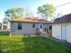 Back exterior of home with wooden steps, a small porch, and green grass at 1155 E Perry St, Indianapolis, IN 46227