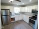Well-lit kitchen with white cabinets, stainless steel appliances, and modern countertops at 1155 E Perry St, Indianapolis, IN 46227