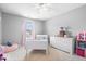 Bright bedroom with soft carpet features a white dresser, plush pink chair and charming white bed frame at 1158 Thistlewood Way, Plainfield, IN 46168