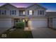 Well-lit two-story townhouse with an attached garage and manicured lawn at 1158 Thistlewood Way, Plainfield, IN 46168