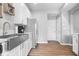 Well-lit kitchen featuring stainless steel appliances, white cabinets, and laminate flooring at 1158 Thistlewood Way, Plainfield, IN 46168