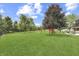 Expansive backyard featuring lush lawn, mature trees, playground set and a wrought iron fence at 1202 Vestman Ct, Greenwood, IN 46143