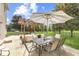 Outdoor dining area in the backyard with patio table, chairs, and a shade umbrella at 1202 Vestman Ct, Greenwood, IN 46143
