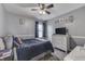 This gray bedroom features a ceiling fan, a window, and a bed with a navy blue comforter at 1202 Vestman Ct, Greenwood, IN 46143