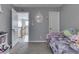 This bedroom is decorated with gray walls, gray carpet, and purple accents in the bedding and decor at 1202 Vestman Ct, Greenwood, IN 46143