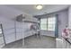 This bedroom features a lofted bed, a desk underneath, and a window with blue curtains at 1202 Vestman Ct, Greenwood, IN 46143