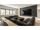 Finished basement boasts a comfortable gray sectional sofa, stone-accented window well, and media center at 12022 Otto Ln, Carmel, IN 46032
