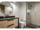 Modern bathroom featuring a glass-enclosed shower, black fixtures, a round mirror, and stylish vanity at 12022 Otto Ln, Carmel, IN 46032