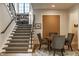 Dining area near the staircase features a round table with gray chairs and contemporary decor at 12022 Otto Ln, Carmel, IN 46032