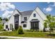 Beautiful home exterior with black trim, white brick, and vibrant landscaping, perfect for curb appeal at 12022 Otto Ln, Carmel, IN 46032