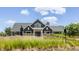 Charming craftsman-style home featuring a covered front porch and professionally landscaped yard with native grasses at 12022 Otto Ln, Carmel, IN 46032