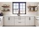Modern kitchen with white cabinets, floating wood shelves, and sleek countertops at 12022 Otto Ln, Carmel, IN 46032