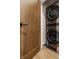 Modern laundry featuring stacked washer and dryer with a wooden door at 12022 Otto Ln, Carmel, IN 46032