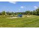 Fun playground with slides and swings set in a large grassy field, ideal for children to play and explore at 12022 Otto Ln, Carmel, IN 46032
