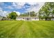 Exterior view of the house and backyard, with a large lawn and mature trees at 124 Bess Blvd, Pendleton, IN 46064