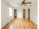 A bedroom with wood-look floors, two doors, and a large window with patterned curtains at 124 Bess Blvd, Pendleton, IN 46064