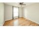 A bright bedroom with wood-look flooring and a window with checkered curtains at 124 Bess Blvd, Pendleton, IN 46064