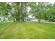 A single story home boasts a bright green lawn, mature shade trees and a pop of color from the yellow front door at 124 Bess Blvd, Pendleton, IN 46064