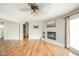 Spacious living area with wood floors, a white fireplace, TV mount, and view of a dark stained interior door at 124 Bess Blvd, Pendleton, IN 46064