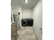 A modern laundry room featuring gray tile floor, washer, dryer, and water heater at 1248 Cassine Pl, Greenwood, IN 46143