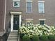 Inviting townhouse entrance with black door, decorative wreath, and neatly landscaped flowerbed at 12838 Bird Cage, Carmel, IN 46032