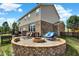 Inviting backyard with a brick fire pit, comfortable seating, and a manicured lawn at 14095 Northcoat Pl, Fishers, IN 46038
