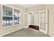 Bright empty room with gray carpet, large windows with a view, and glass doors leading to another space at 14095 Northcoat Pl, Fishers, IN 46038