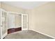 Neutral bedroom featuring gray carpeting and glass double doors leading to another room with dark wood floors at 14095 Northcoat Pl, Fishers, IN 46038