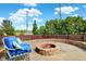 Outdoor fire pit area with comfortable blue lounge chairs and a brick surround at 14095 Northcoat Pl, Fishers, IN 46038