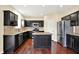 Open kitchen features dark cabinets, stainless steel appliances, an island and stone countertops at 14095 Northcoat Pl, Fishers, IN 46038