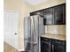 Modern kitchen offers stainless steel appliances and stone countertops with dark cabinets at 14095 Northcoat Pl, Fishers, IN 46038