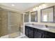 Main bathroom with double vanity, granite countertop, shower, and decorative mirrors at 14095 Northcoat Pl, Fishers, IN 46038