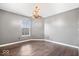 Spacious bedroom with hardwood floors, neutral walls, and a statement chandelier adding elegance at 143 W Clear Lake Ct, Westfield, IN 46074