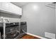 Well-equipped laundry area with modern washer and dryer units, overhead cabinets, and hardwood flooring at 143 W Clear Lake Ct, Westfield, IN 46074