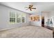 Open-concept living room with neutral carpet, large windows, and a view into the kitchen at 143 W Clear Lake Ct, Westfield, IN 46074