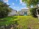 A well maintained backyard with lush grass, surrounded by mature trees, and a charming home at 146 E Broadway St, Shelbyville, IN 46176