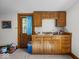 Compact kitchenette featuring classic wooden cabinetry, sink, and adjacent door with window at 146 E Broadway St, Shelbyville, IN 46176